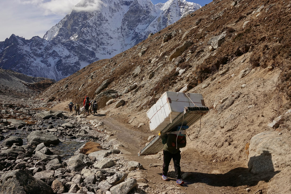Porters carrying heavy loads to Everest base camp