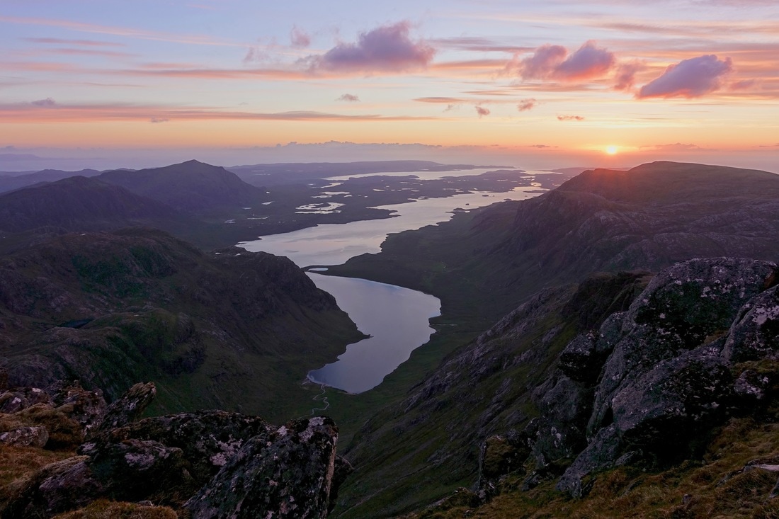 Looking west at sunset from the A' Mhaighdean summit hike over Fionn Loch towards the coast
