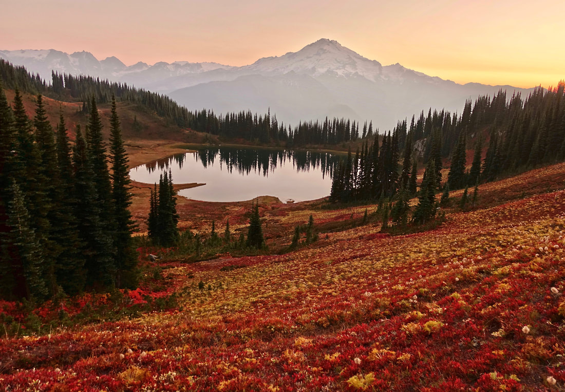 Fall colors over a smoky Image Lake with a view of Glacier Peak in October Washington